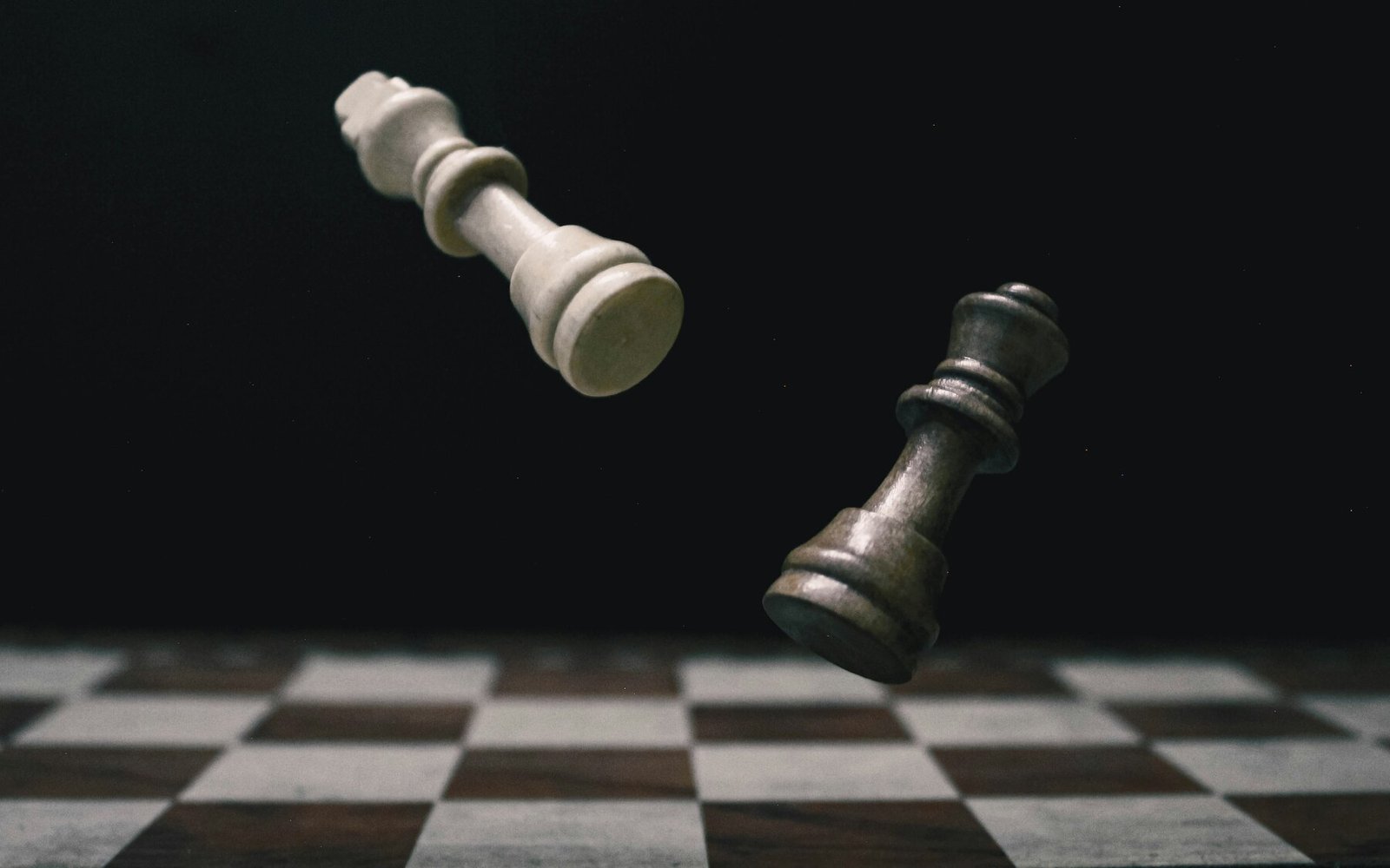 Two contrasting chess pieces moving above a chessboard